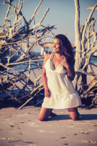 girl kneels on the beach