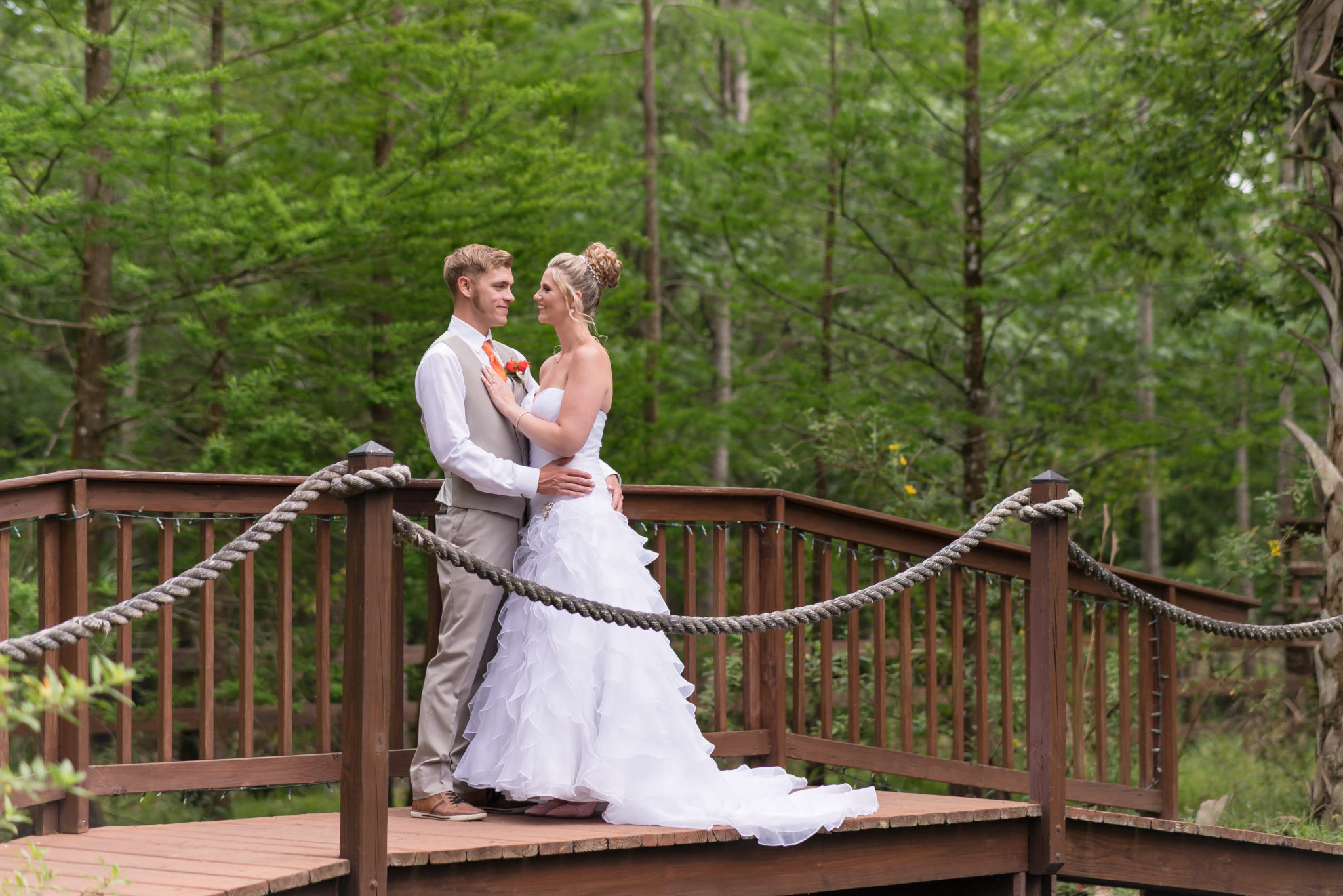 Newly married couple stand on a bridge