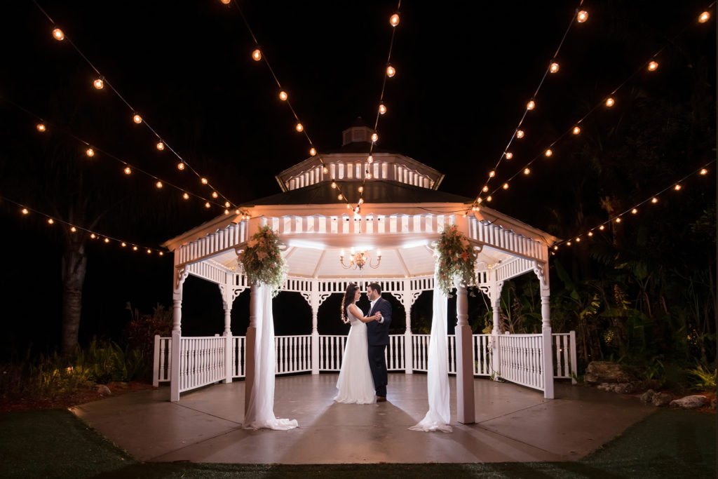 Husband and Wife dance under a lit gazebo at night at Pavillion at Mixson Farms